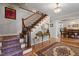 Stylish foyer with a staircase, hardwood floors, and a chandelier, leading to a dining area with table at 609 Brookview Dr, Chapel Hill, NC 27514