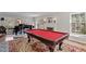 Spacious living room featuring a red pool table, fireplace, and grand piano at 609 Brookview Dr, Chapel Hill, NC 27514