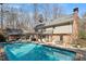 Lush backyard featuring a sparkling pool with ample seating, surrounded by mature trees and greenery at 609 Brookview Dr, Chapel Hill, NC 27514