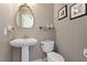 Chic powder room featuring a pedestal sink, elegant mirror, and neutral wallpaper at 609 Brookview Dr, Chapel Hill, NC 27514