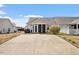 Wide backyard with a paved surface leads to a screen porch and the rear of the house at 75 E Moss Creek Dr, Clayton, NC 27520