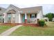 Inviting home exterior with a charming front porch, lush lawn, and manicured landscaping at 75 E Moss Creek Dr, Clayton, NC 27520