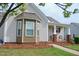 Lovely home exterior showcasing a cozy porch area, brick accents, and inviting curb appeal at 75 E Moss Creek Dr, Clayton, NC 27520