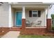 Cozy front porch with brick columns, seating area, and a bright blue front door at 75 E Moss Creek Dr, Clayton, NC 27520