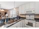 Bright kitchen with white cabinets, granite countertops, and modern appliances, open to the living space at 75 E Moss Creek Dr, Clayton, NC 27520