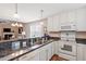 Bright kitchen with white cabinets, granite countertops, and modern appliances, open to the living space at 75 E Moss Creek Dr, Clayton, NC 27520