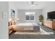 A bright bedroom featuring neutral walls and flooring and furnished with light colored furniture at 7818 Spungold St, Raleigh, NC 27617
