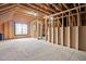 Unfinished attic with exposed wood framing, a window, and unfinished plywood flooring at 921 Alden Bridge Dr, Cary, NC 27519