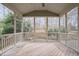 Screened-in porch with wooden flooring, a ceiling fan, and views of the landscaped backyard at 921 Alden Bridge Dr, Cary, NC 27519