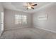 Bright bedroom features neutral walls and carpet, white trim, a ceiling fan, and a window offering outdoor views at 96 Foxtail Ct, Clayton, NC 27520