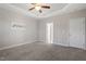 Bedroom with neutral carpet and walls features a ceiling fan, an interior door and a window providing natural light at 96 Foxtail Ct, Clayton, NC 27520
