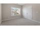 Bedroom features a window, neutral carpet, and double doors at 96 Foxtail Ct, Clayton, NC 27520