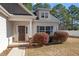 Inviting front entrance with a brick walkway and landscaping, featuring a dark-colored front door at 96 Foxtail Ct, Clayton, NC 27520
