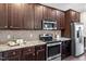 Kitchen featuring stainless steel appliances, granite countertops, dark cabinets, and tile backsplash at 96 Foxtail Ct, Clayton, NC 27520