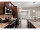 Kitchen boasting granite counters, stainless appliances, large sink, and open view to the sunroom at 96 Foxtail Ct, Clayton, NC 27520