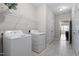 Bright laundry room with tile flooring, shelving, washer, dryer, and access to other rooms at 96 Foxtail Ct, Clayton, NC 27520