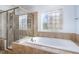 Bathroom featuring a glass shower and large soaking tub with decorative window at 10016 Porto Fino Ave, Wake Forest, NC 27587