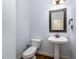 Half bath offers a pedestal sink with elegant fixtures, and decorative mirror at 10016 Porto Fino Ave, Wake Forest, NC 27587