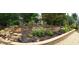 Tranquil backyard garden with beautiful flowers, retaining walls, and meticulous landscaping at 10016 Porto Fino Ave, Wake Forest, NC 27587
