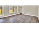Inviting living room featuring a large window and neutral walls with wood-look flooring at 1076 Nc 55, Coats, NC 27521
