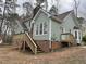 The home's backyard with a view of the brick foundation and wooden deck and stairs at 1116 Shadywood Ln, Raleigh, NC 27603
