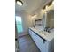 Contemporary bathroom with dual sinks, white cabinets with black hardware, and modern fixtures at 1116 Shadywood Ln, Raleigh, NC 27603