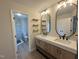 Modern bathroom with double vanity, wood-look cabinets, floating shelves, and glass-enclosed shower at 1116 Shadywood Ln, Raleigh, NC 27603