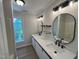 This bathroom features double sinks, a long vanity, modern mirrors, and updated fixtures at 1116 Shadywood Ln, Raleigh, NC 27603