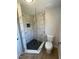 Shower in a luxurious bathroom featuring elegant marble-style tile and a sleek glass enclosure at 1116 Shadywood Ln, Raleigh, NC 27603