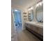 Modern bathroom with double vanity, wood-look cabinets, floating shelves, and glass-enclosed shower at 1116 Shadywood Ln, Raleigh, NC 27603