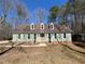 Charming one-story home with a light-green exterior, dormer windows, and beautiful lawn and surrounding trees at 1116 Shadywood Ln, Raleigh, NC 27603