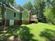 Exterior of home with green siding, brick foundation and back deck at 1116 Shadywood Ln, Raleigh, NC 27603