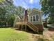 Charming exterior view of the home with a wooden deck and stairs leading to the backyard at 1116 Shadywood Ln, Raleigh, NC 27603