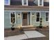 Charming home featuring a wood front door, fresh green paint, and manicured landscaping at 1116 Shadywood Ln, Raleigh, NC 27603