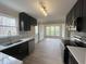 Modern kitchen featuring black cabinets, stainless steel appliances, white countertops, and a view of the dining room at 1116 Shadywood Ln, Raleigh, NC 27603