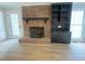 Cozy living room featuring a brick fireplace, built-in shelving, and wood-look floors at 1116 Shadywood Ln, Raleigh, NC 27603