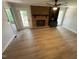 Cozy living room featuring a brick fireplace, built-in shelves, and new flooring at 1116 Shadywood Ln, Raleigh, NC 27603