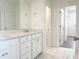 Bright bathroom with double vanity, white cabinets, marble tile floors, and access to a walk-in closet at 114 Tee Time Ter, Benson, NC 27504