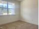 A carpeted bedroom is brightly lit with a large window overlooking the yard at 114 Tee Time Ter, Benson, NC 27504