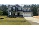 Beautiful two-story home with blue siding, stone accents, and a spacious two-car garage at 114 Tee Time Ter, Benson, NC 27504