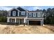 Beautiful two-story home with a dark blue exterior, a two-car garage, and stone accents on the front facade at 114 Tee Time Ter, Benson, NC 27504