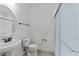 Well-lit bathroom features a pedestal sink, toilet, and a modern shower with glass door at 1146 Blue Bird Ln, Wake Forest, NC 27587