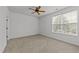 Bright bedroom with a ceiling fan, carpeted floors, and natural light through a large window at 1146 Blue Bird Ln, Wake Forest, NC 27587
