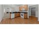 Open kitchen area with wooden cabinets, laminate floors, modern appliances, and a granite breakfast bar at 1146 Blue Bird Ln, Wake Forest, NC 27587