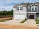 Two-story townhome with a 2-car garage, light gray siding, and a well-lit driveway at 1165 Abbott St, Mebane, NC 27302