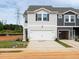 Two story townhome with a 2-car garage and light gray siding, set on a lot ready for final landscaping at 1165 Abbott St, Mebane, NC 27302