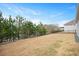 Expansive backyard featuring a black metal fence, lush trees and a tranquil view of the pond at 1206 Linkwood Way, Fuquay Varina, NC 27526