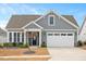 Charming home featuring gray siding, stone accents, well-manicured landscaping, and a two-car garage at 1206 Linkwood Way, Fuquay Varina, NC 27526