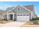 Charming home showcasing a two-car garage, well-manicured lawn and attractive gray siding at 1206 Linkwood Way, Fuquay Varina, NC 27526