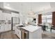 Spacious kitchen featuring white cabinets, stainless steel appliances, island with seating, and an open-concept design at 1206 Linkwood Way, Fuquay Varina, NC 27526